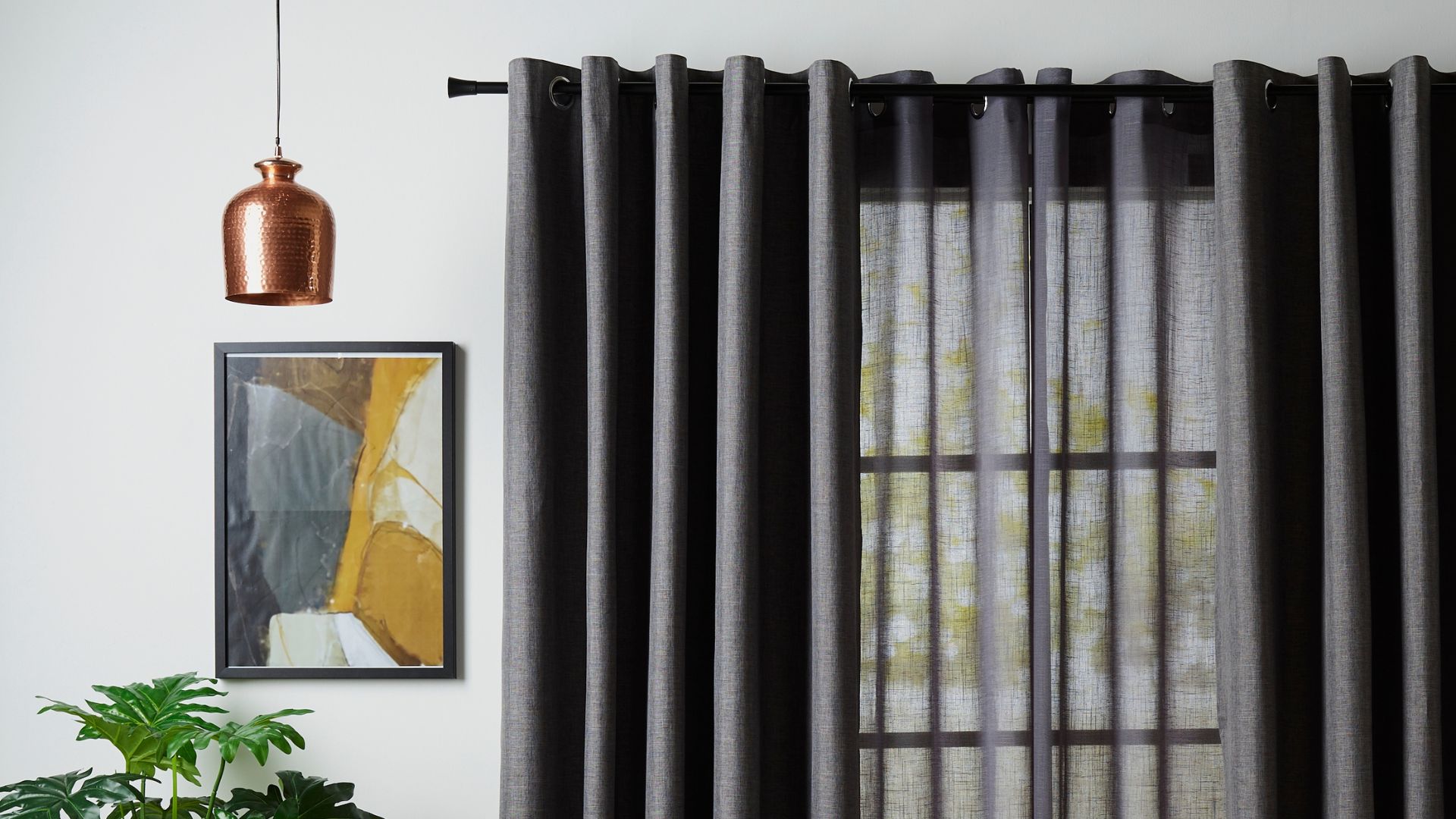 Semi-sheer grey curtains hung on a black curtain rod