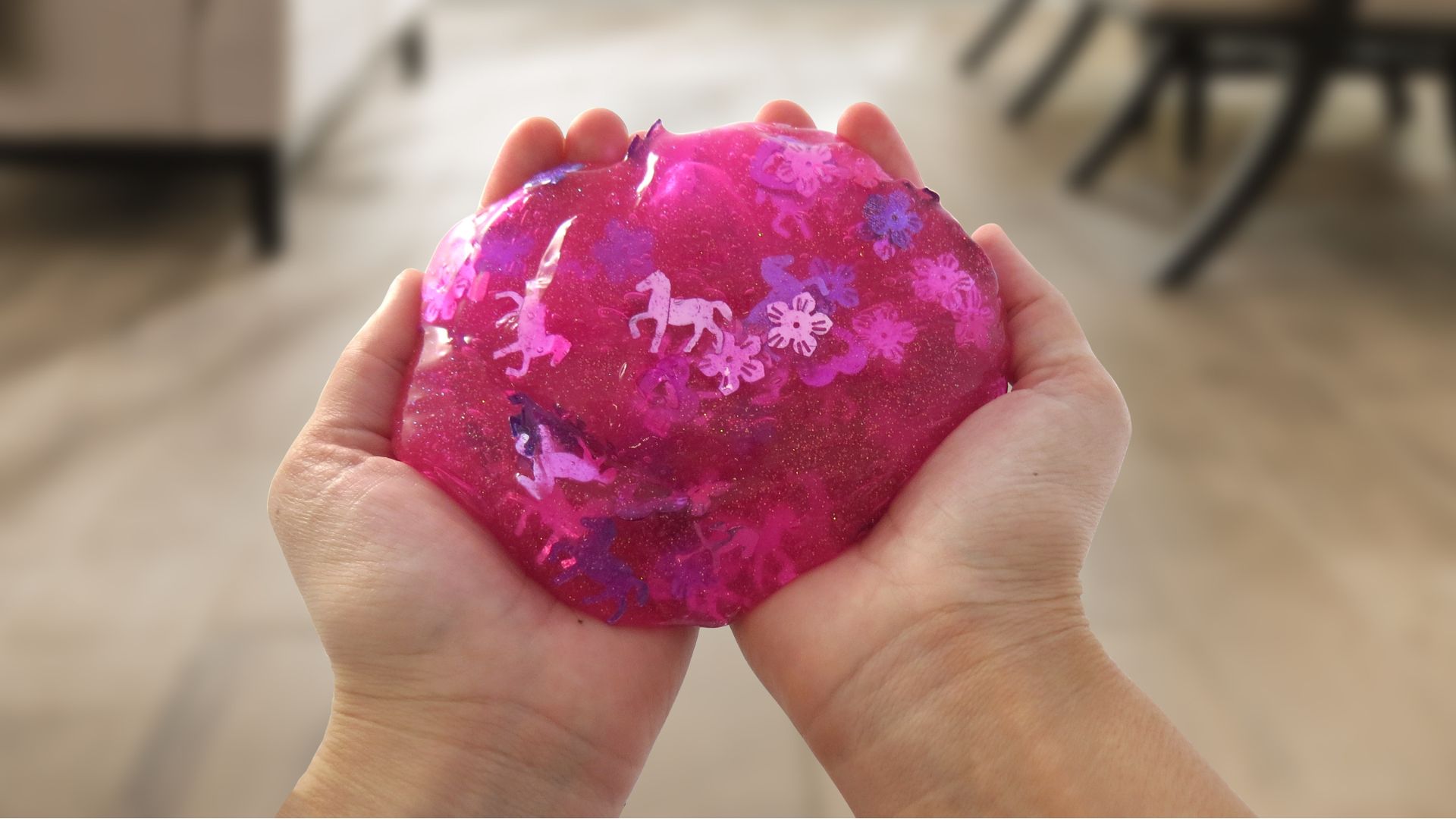 Semi-transparent pink glitter slime with metallic flower and horse sequins