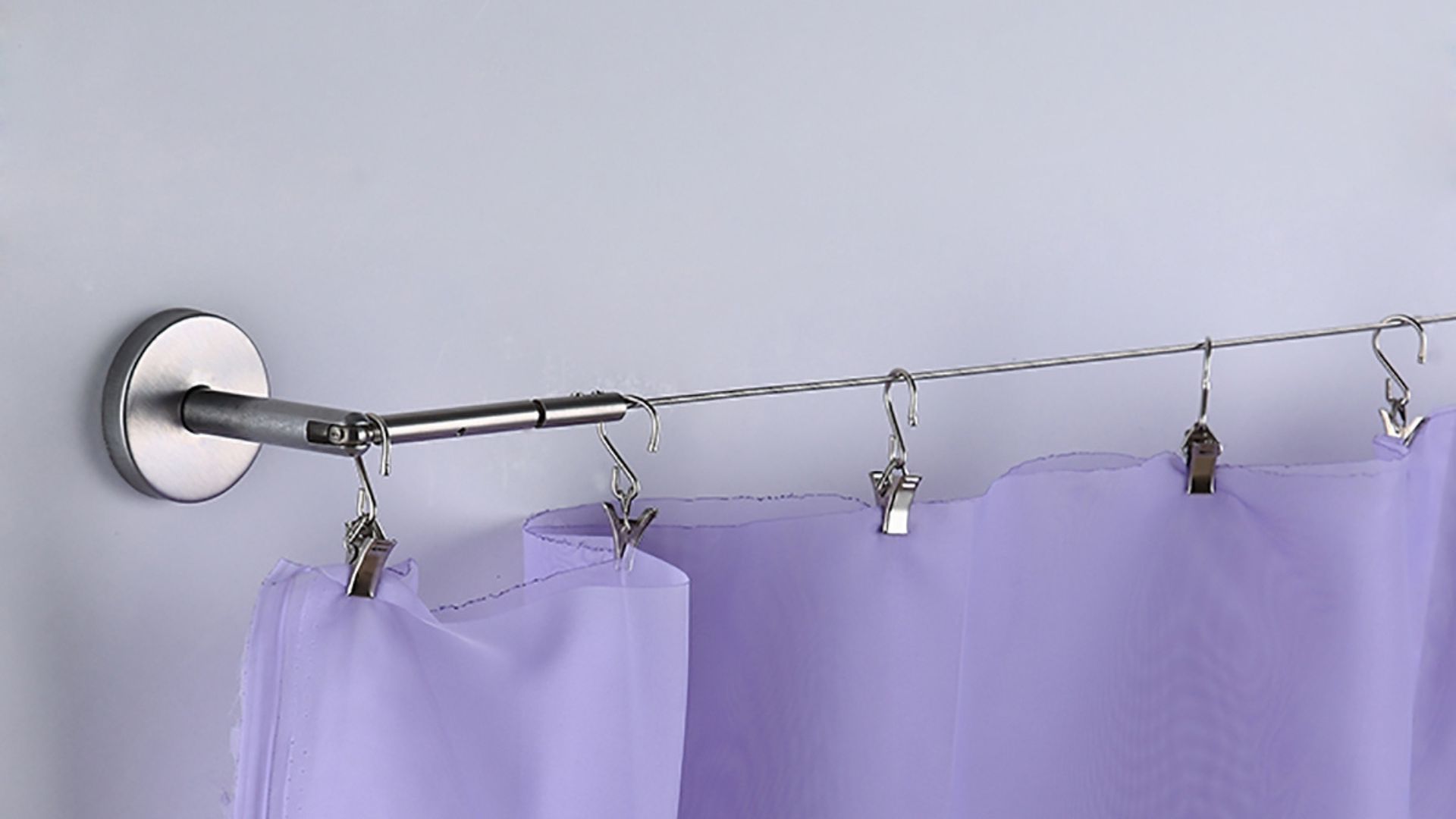 Purple sheer curtains hung on a stretch wire