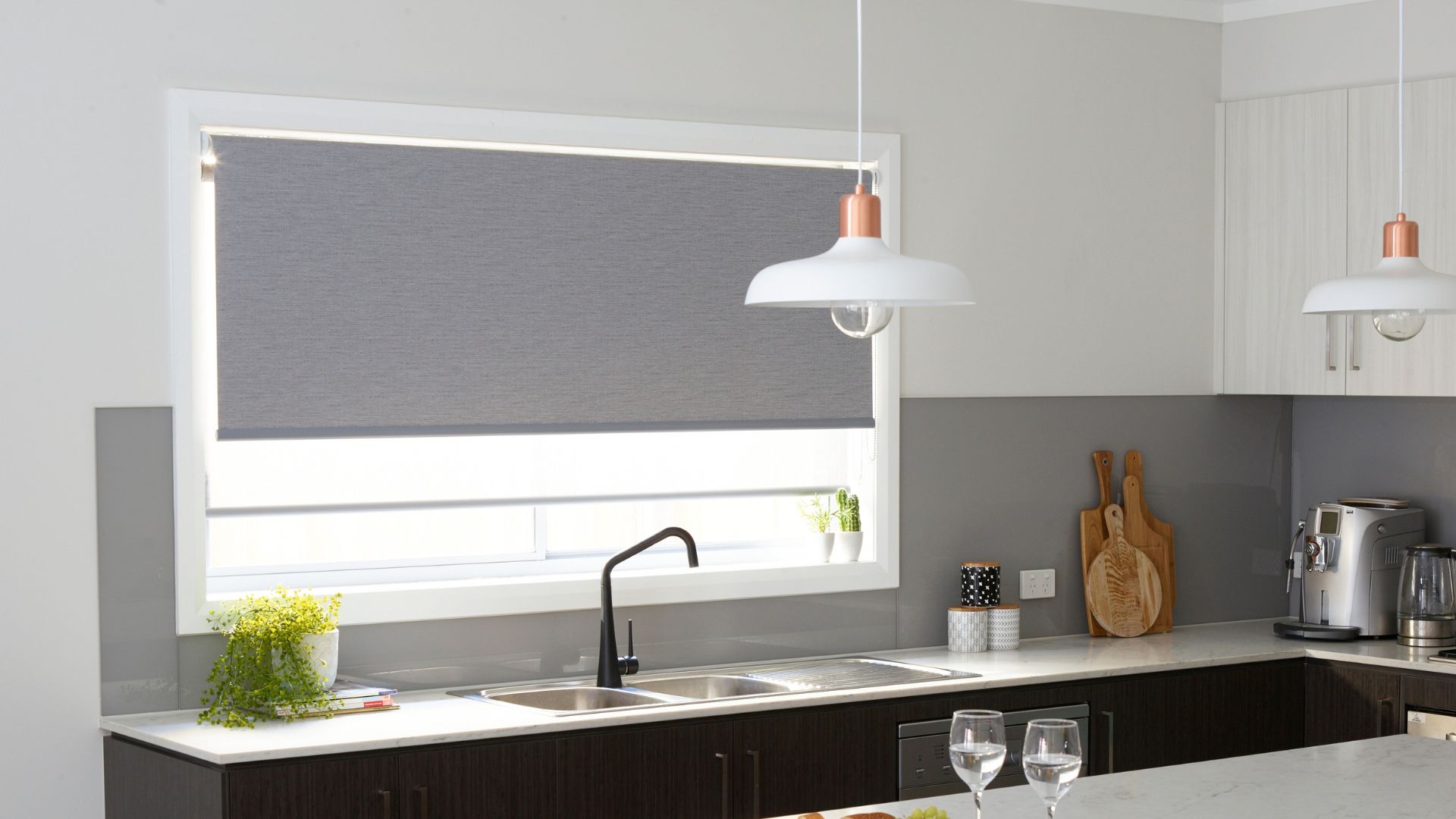 Sheet white layered with grey roller blinds in the kitchen